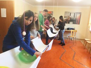 Unter Zeitdruck eine Lösung finden: Das Team baut an einer Rettung für Eier, die von der Decke hängen. Nur durch gute Teamarbeit zerbrechen die Eier nicht, als der Faden nach punkt 20 Minuten durchtrennt wird.